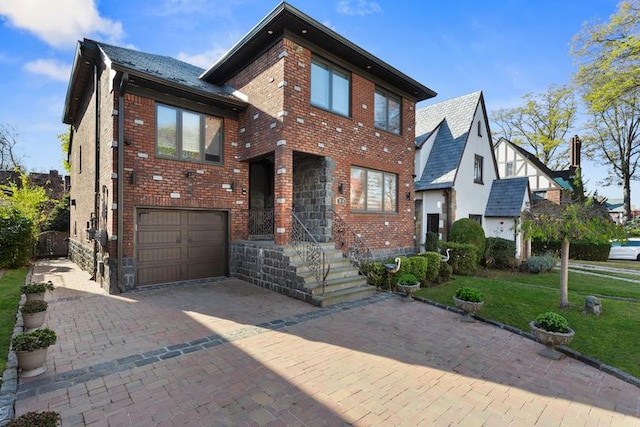 view of front of house featuring decorative driveway, brick siding, an attached garage, and a front yard