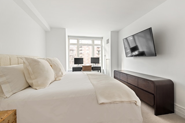 bedroom with light carpet and a desk