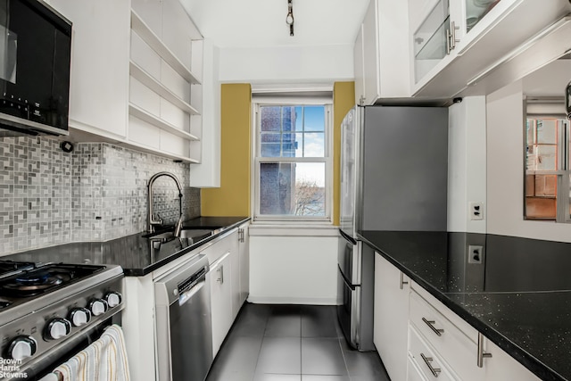 kitchen with open shelves, dark tile patterned flooring, stainless steel appliances, white cabinetry, and a sink