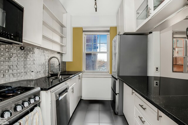 140 Cabrini Blvd Unit 37, New York City, NY 10033 - kitchen featuring appliances with stainless steel finishes, open shelves, dark tile patterned floors, white cabinetry, and backsplash