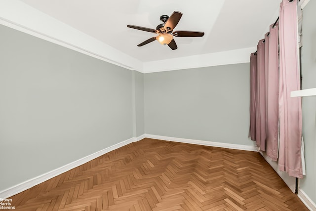 unfurnished room featuring a ceiling fan and baseboards