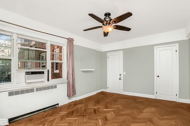 spare room featuring a ceiling fan, radiator heating unit, cooling unit, and baseboards