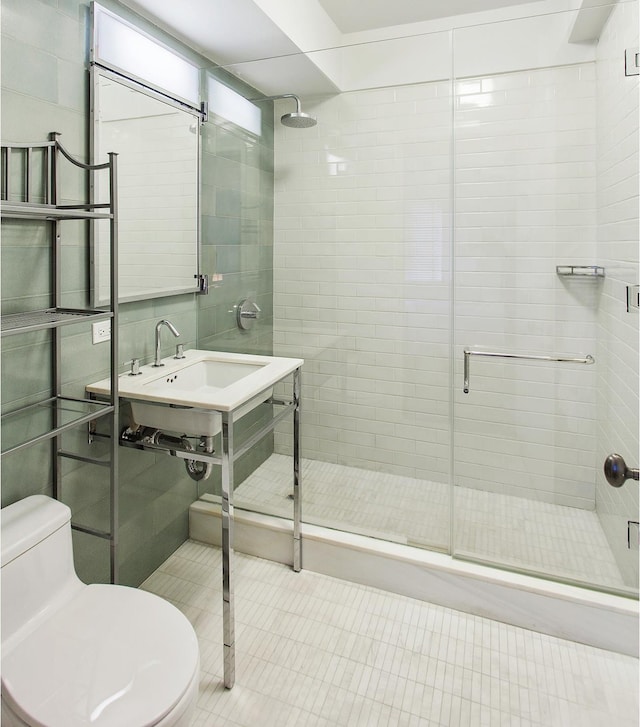 bathroom with toilet, tile patterned flooring, a shower stall, and tile walls