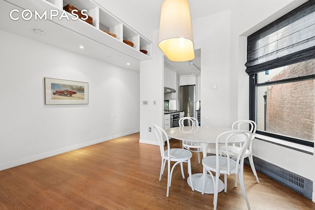 dining area featuring baseboards and light wood-style flooring