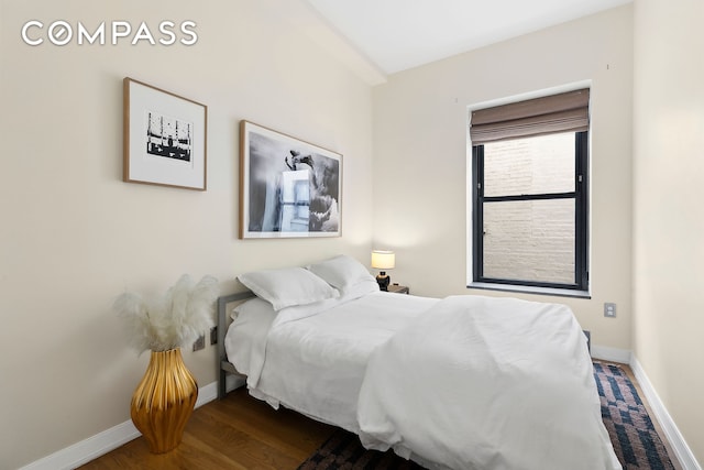 bedroom with baseboards and wood finished floors
