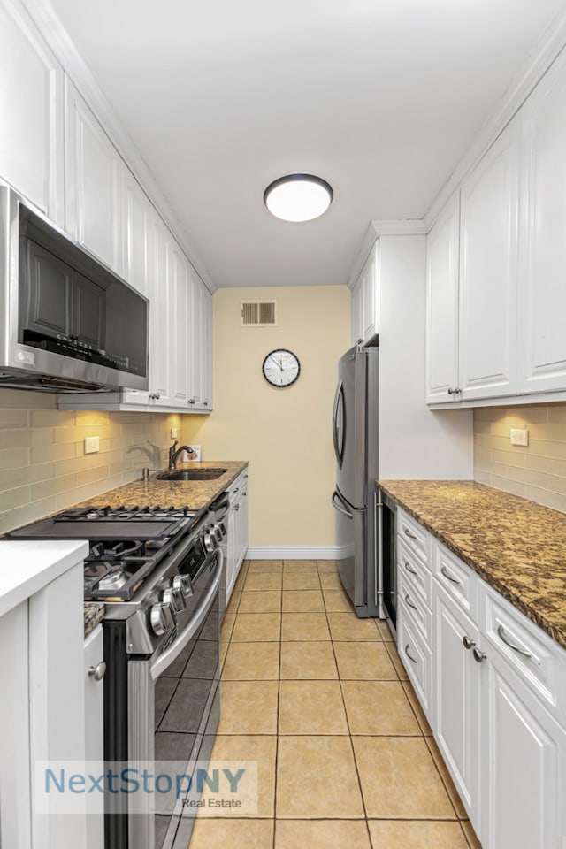 kitchen with visible vents, light tile patterned flooring, a sink, white cabinets, and appliances with stainless steel finishes