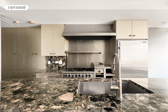 kitchen with visible vents, dark stone countertops, appliances with stainless steel finishes, cream cabinetry, and a sink