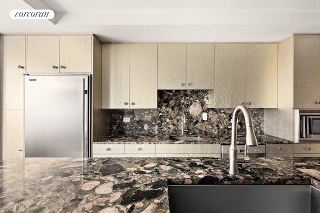 kitchen featuring visible vents, refrigerator, a sink, stainless steel microwave, and cream cabinets