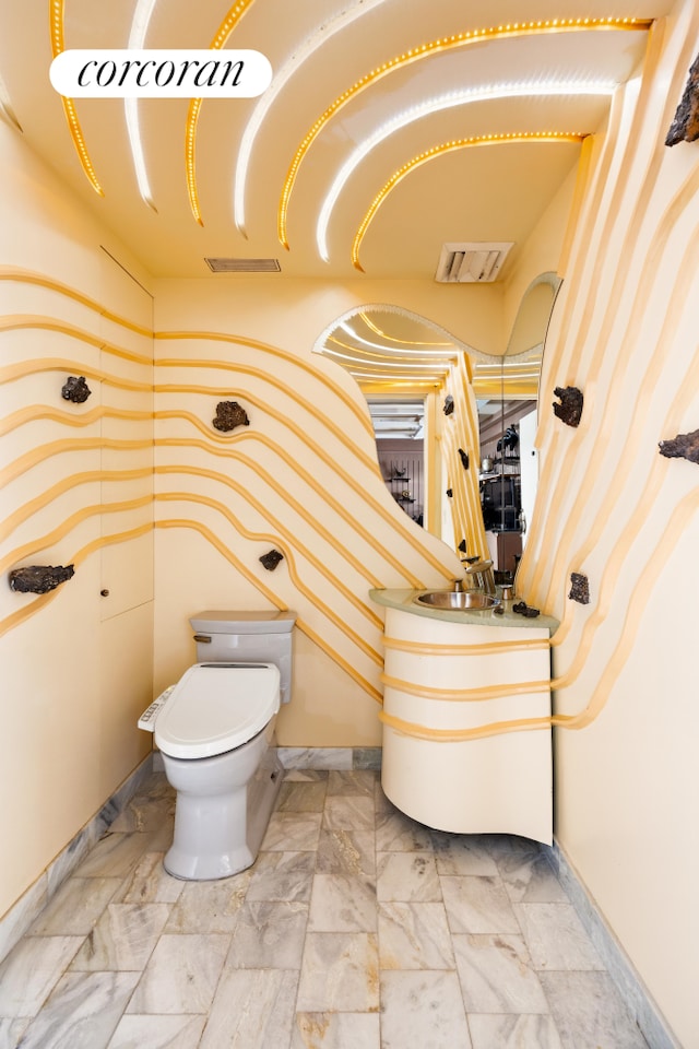 bathroom with vanity, toilet, visible vents, and marble finish floor