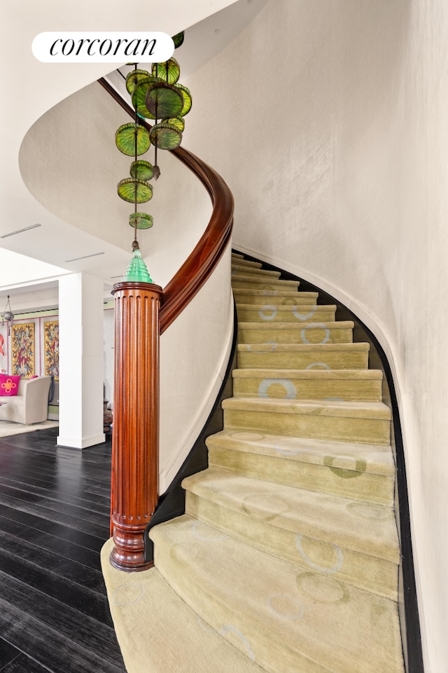 staircase with baseboards and wood finished floors