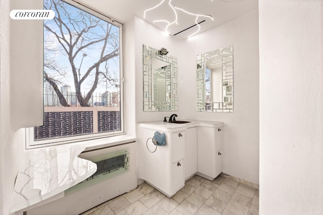 bathroom featuring plenty of natural light, marble finish floor, and vanity