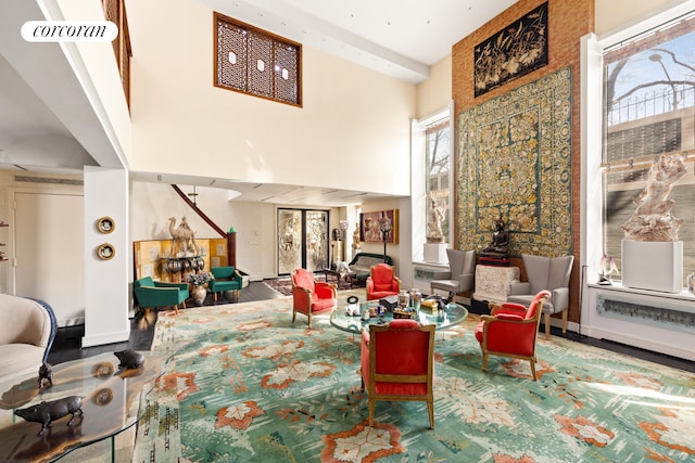 living area featuring visible vents, a high ceiling, and wood finished floors