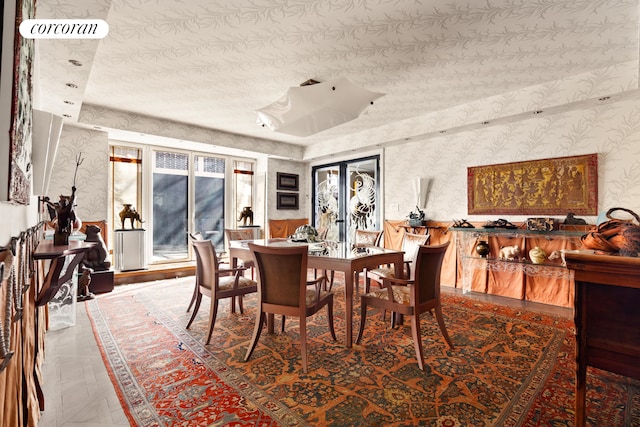 dining space featuring wallpapered walls, french doors, and a textured ceiling