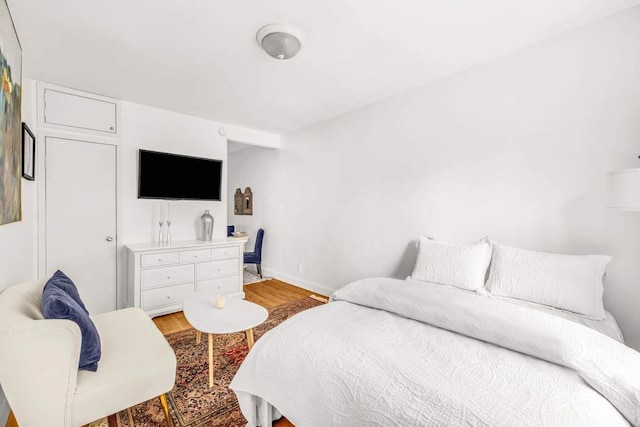 bedroom with baseboards and light wood finished floors