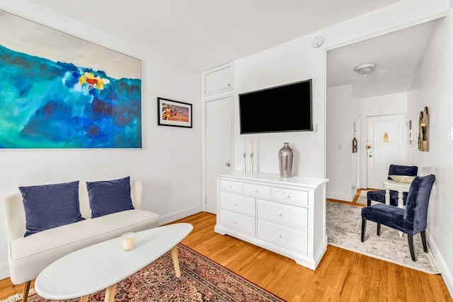 sitting room with baseboards and light wood-style floors