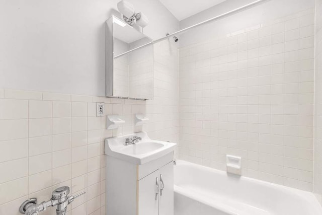 bathroom with shower / bath combination, tile walls, and vanity