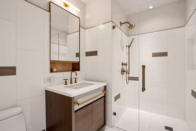 full bath with vanity, tile walls, toilet, and tiled shower