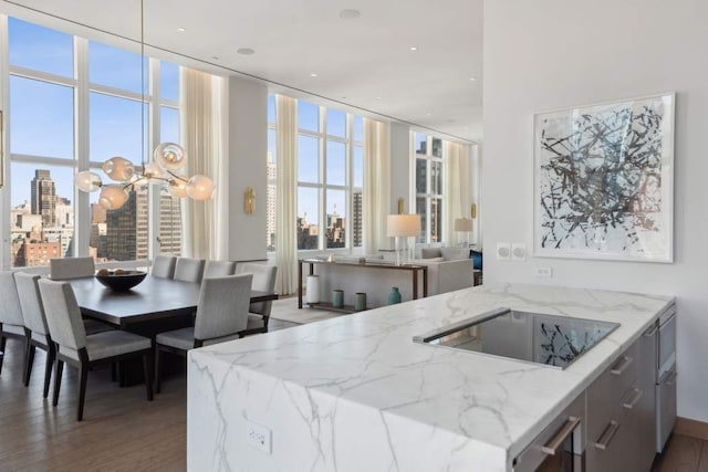 kitchen with a city view, light wood-style flooring, black electric cooktop, and light stone countertops