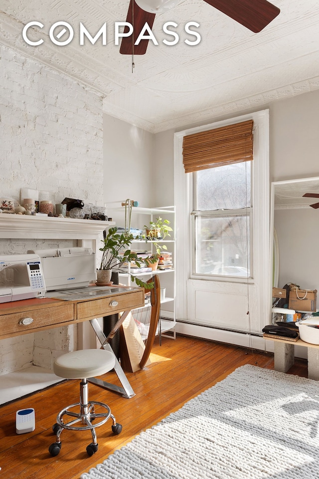 home office featuring wood finished floors, a ceiling fan, and ornamental molding