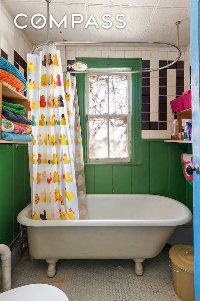 bathroom with shower / bath combo with shower curtain, toilet, and tile patterned flooring