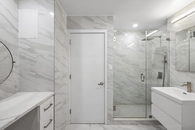 full bath with a marble finish shower, recessed lighting, marble finish floor, and vanity