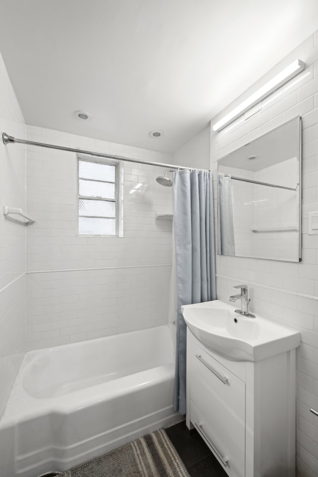 bathroom featuring tile patterned floors, shower / bathtub combination with curtain, tile walls, and vanity