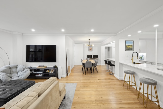 living area featuring light wood finished floors, recessed lighting, and crown molding