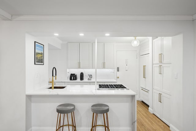 150 E 27th St Unit 4Fg, New York City, NY 10016 - kitchen featuring high quality appliances, ornamental molding, a sink, tasteful backsplash, and white cabinetry