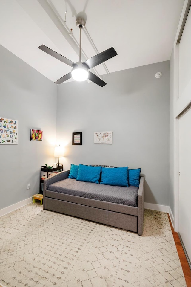 living room with wood finished floors, a ceiling fan, and baseboards