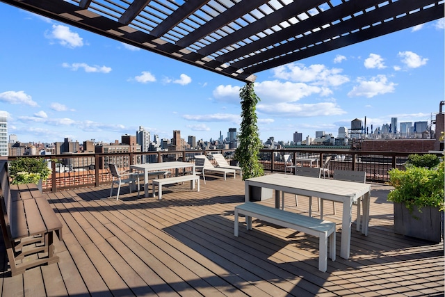 wooden terrace with a view of city, outdoor dining space, and a pergola