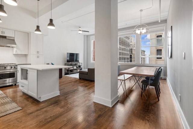 kitchen featuring high end stainless steel range, under cabinet range hood, dark wood-style floors, white cabinets, and decorative backsplash