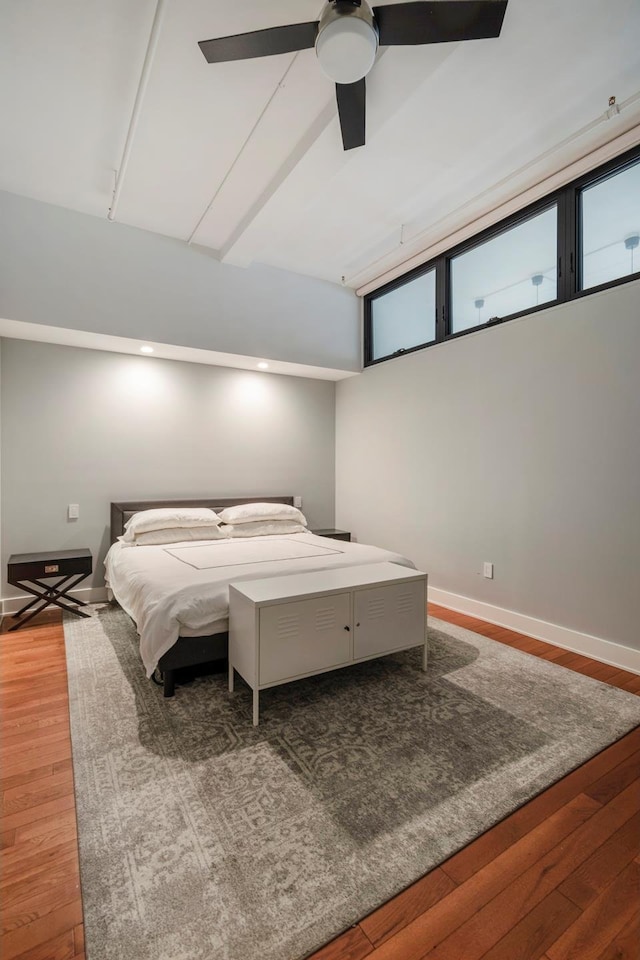 bedroom featuring baseboards, wood finished floors, and a ceiling fan