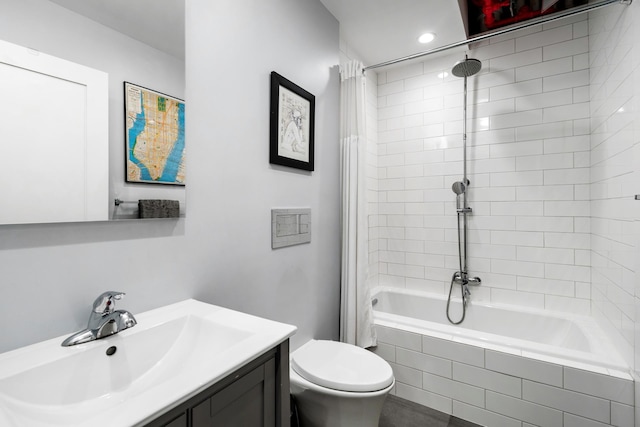 bathroom with vanity, toilet, and tiled shower / bath combo