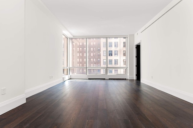 unfurnished room featuring a wealth of natural light, baseboards, and hardwood / wood-style flooring