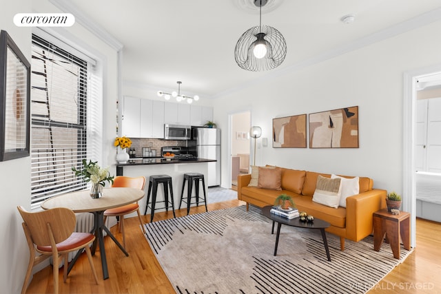 living area featuring crown molding, plenty of natural light, visible vents, and light wood-type flooring