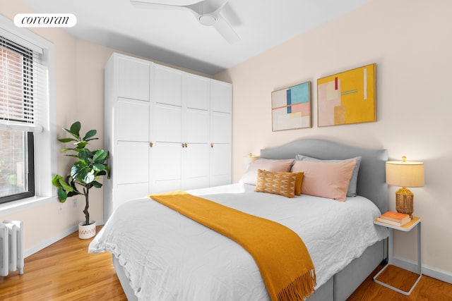 bedroom with visible vents, baseboards, radiator heating unit, and light wood-style floors