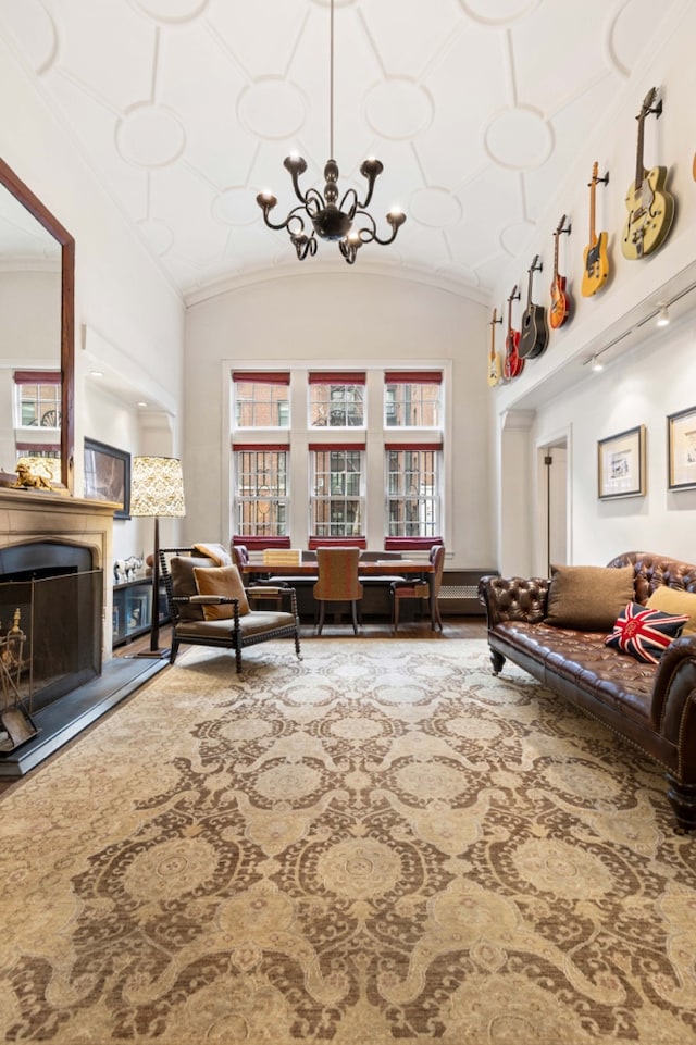 living room with a chandelier, ornamental molding, and vaulted ceiling