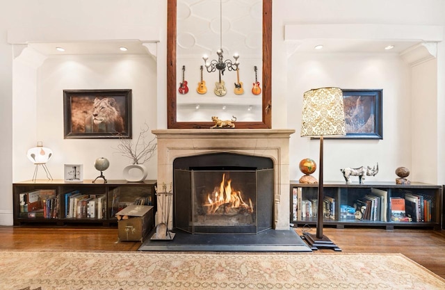 living room featuring a warm lit fireplace, wood finished floors, and crown molding