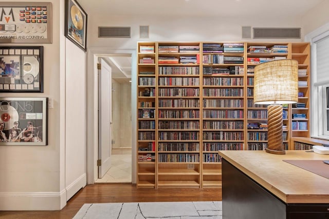 wine room featuring visible vents, baseboards, and wood finished floors