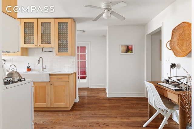 kitchen featuring wood finished floors, light brown cabinets, white gas stove, light countertops, and backsplash