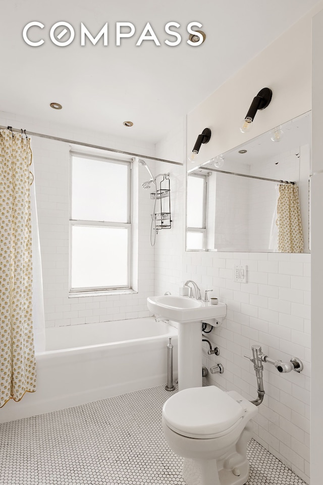 full bathroom featuring tile patterned floors, toilet, tile walls, and shower / bathtub combination with curtain