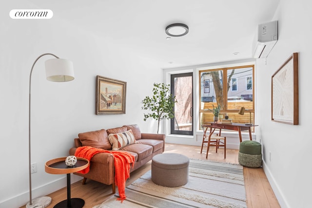 living area with a wall unit AC, wood finished floors, visible vents, and baseboards