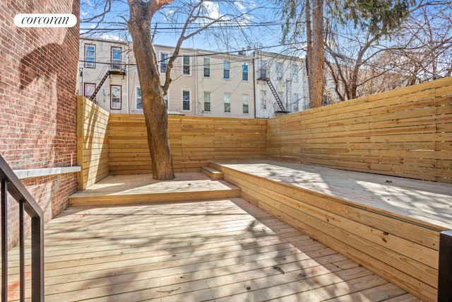 wooden terrace with a fenced backyard