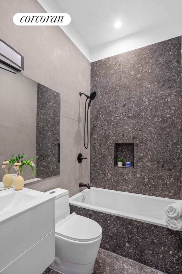 bathroom with vanity, an AC wall unit, shower / bath combination, tile walls, and toilet