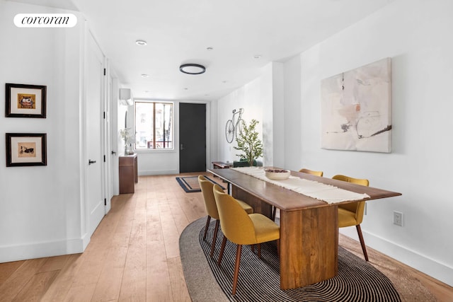 dining area with baseboards, light wood-style floors, and visible vents