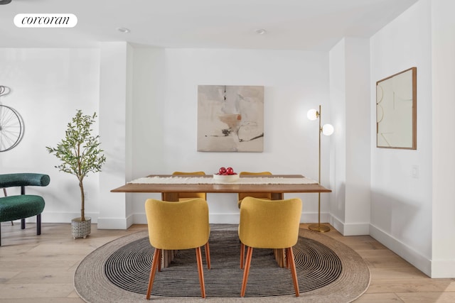dining area featuring baseboards, light wood-style flooring, and breakfast area