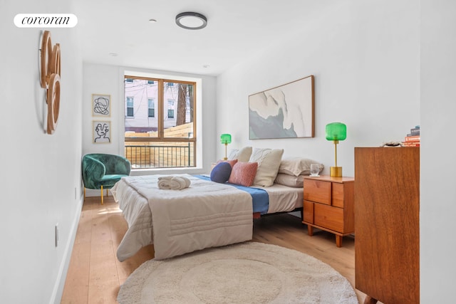 bedroom with light wood-type flooring and baseboards