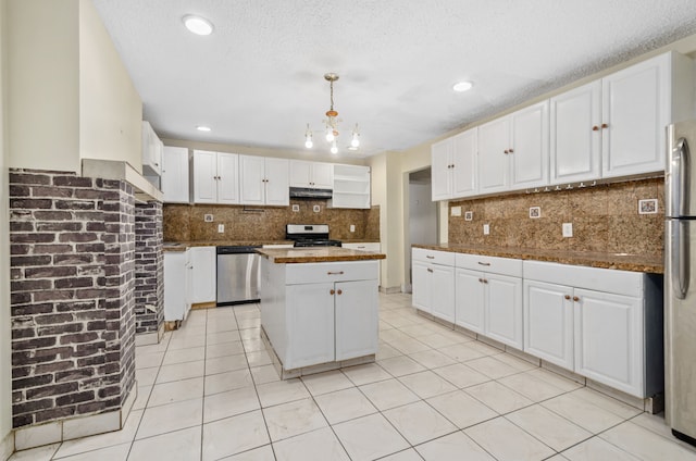 kitchen with light tile patterned floors, appliances with stainless steel finishes, and white cabinets