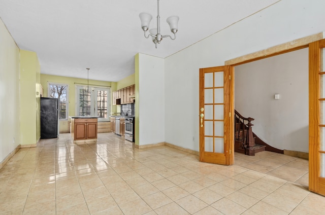 interior space featuring light tile patterned floors, baseboards, a notable chandelier, and appliances with stainless steel finishes