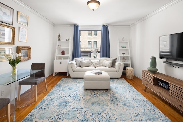 living room featuring wood finished floors, baseboards, and ornamental molding